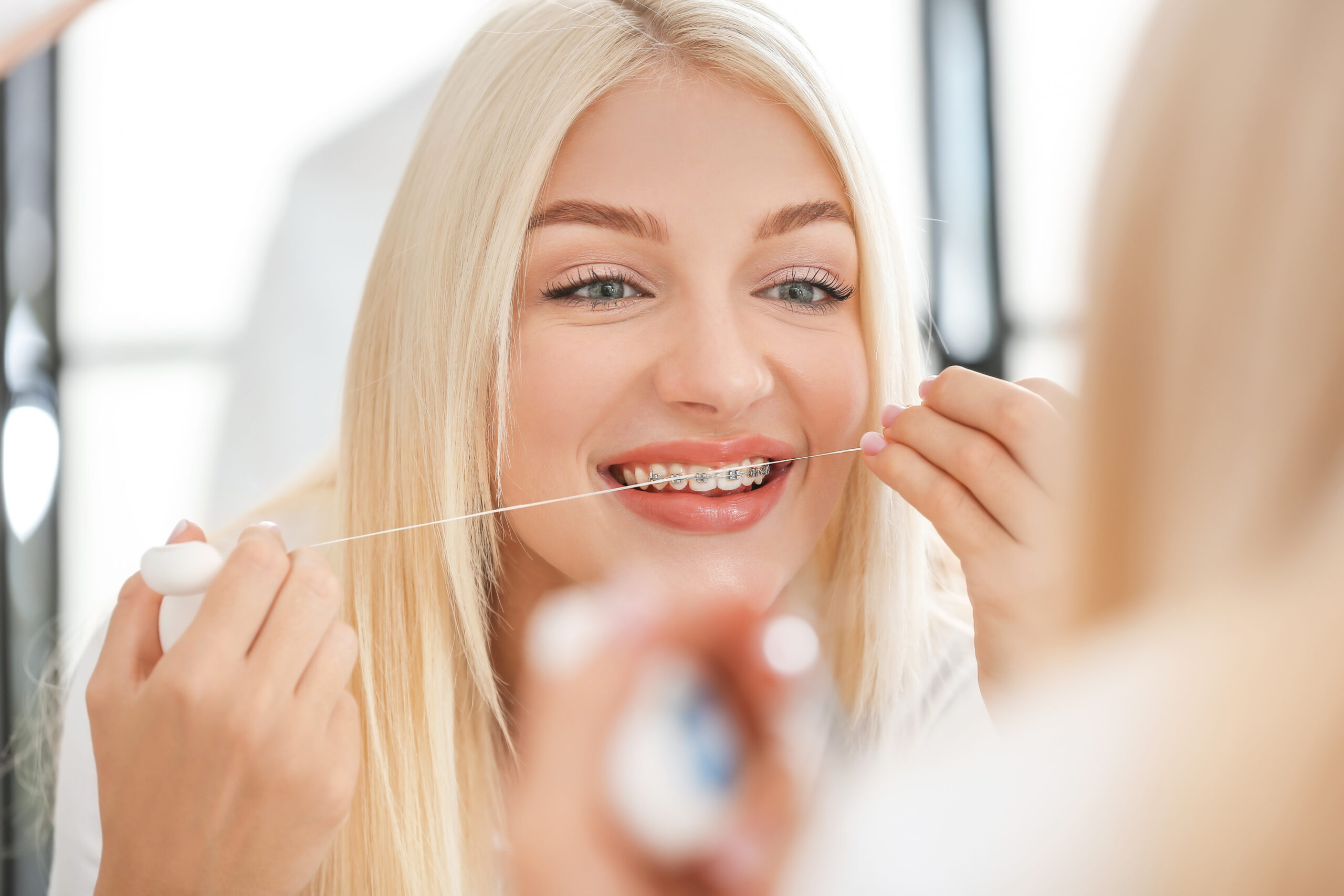 Young woman with dental braces and floss